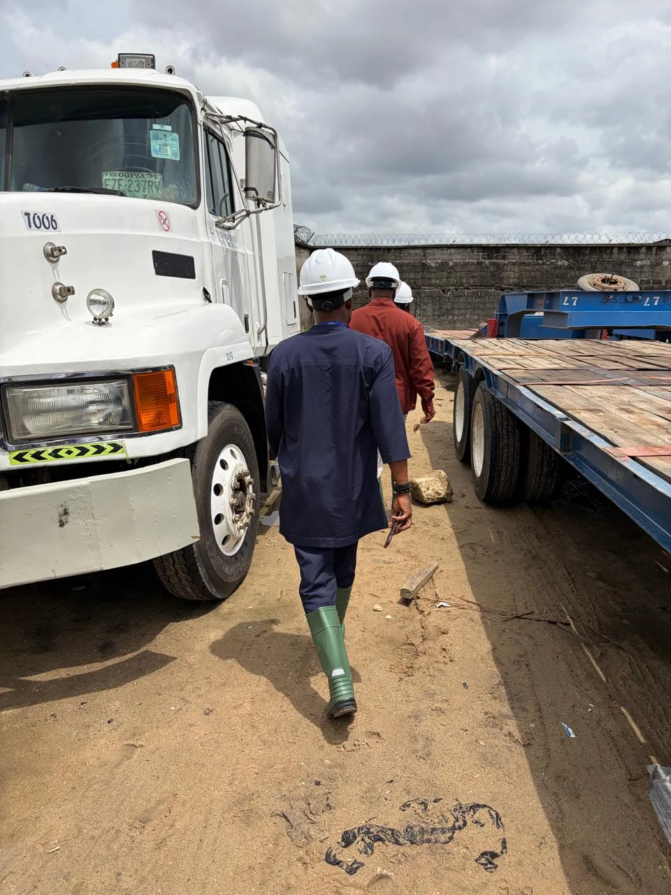 Personnel beside a truck and industrial materials at the logistics yard